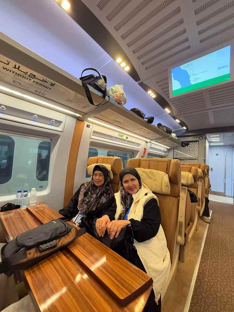 Dua jamaah haji plus Elharamain Wisata duduk di dalam gerbong kereta cepat Haramain