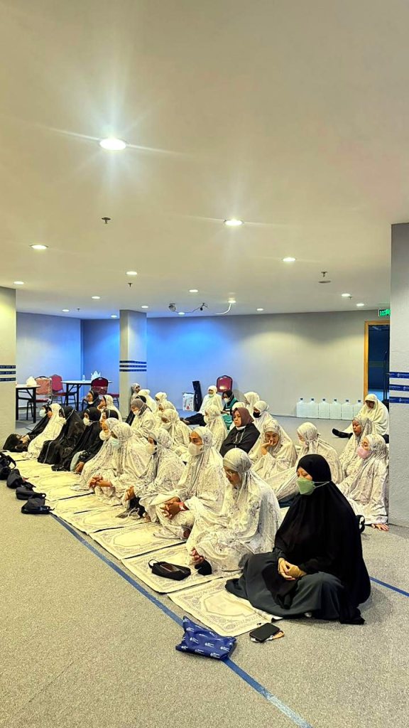 Jamaah haji wanita bermukena mengikuti kajian pemantapan manasik di ruang transit